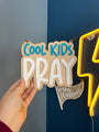 Cool Kids Pray blue and white sign